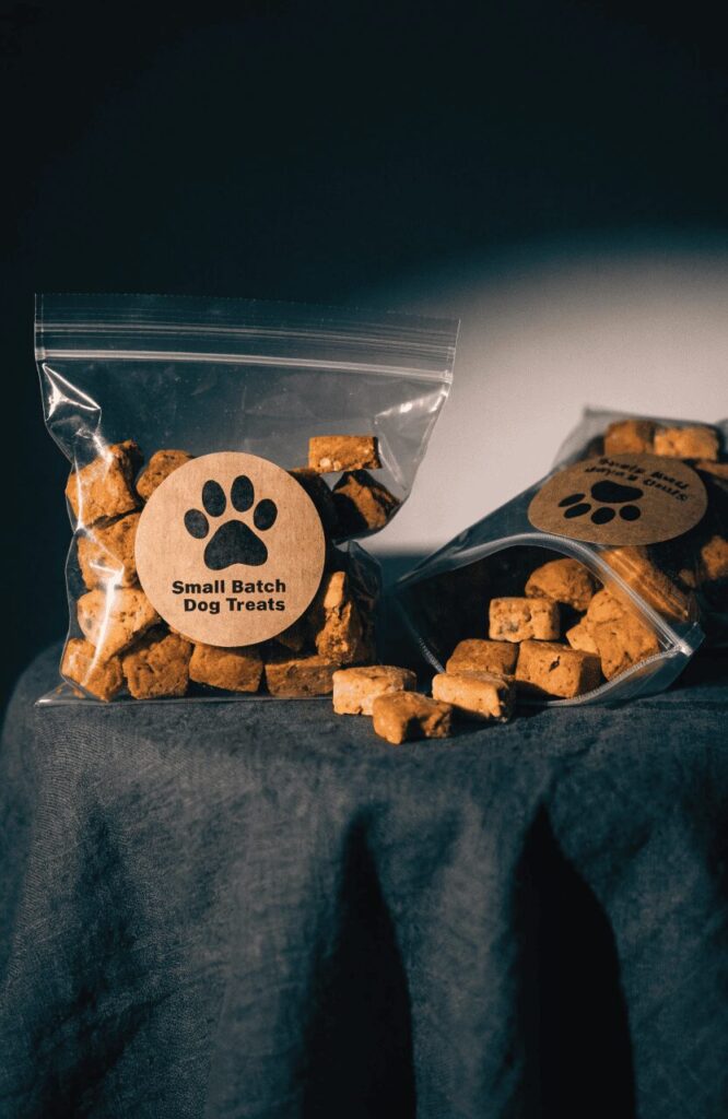 clear zip bag with bold branded sticker label holding dog treats on dark surface