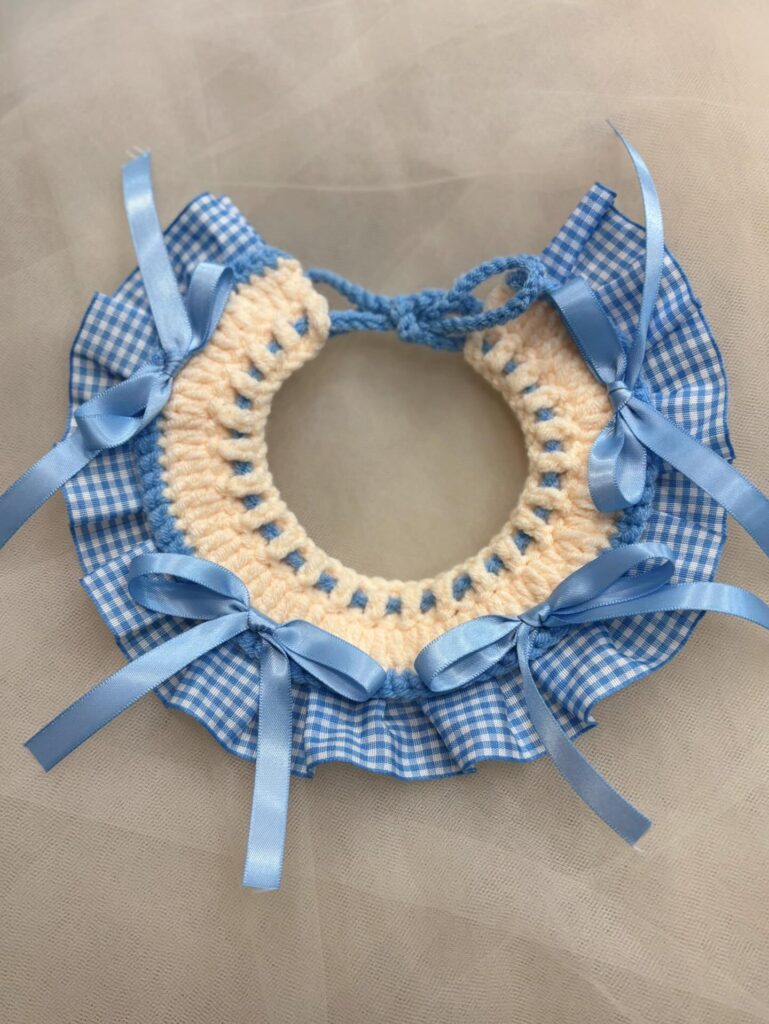 crochet dog collar with blue gingham fabric and satin ribbon bows flat lay