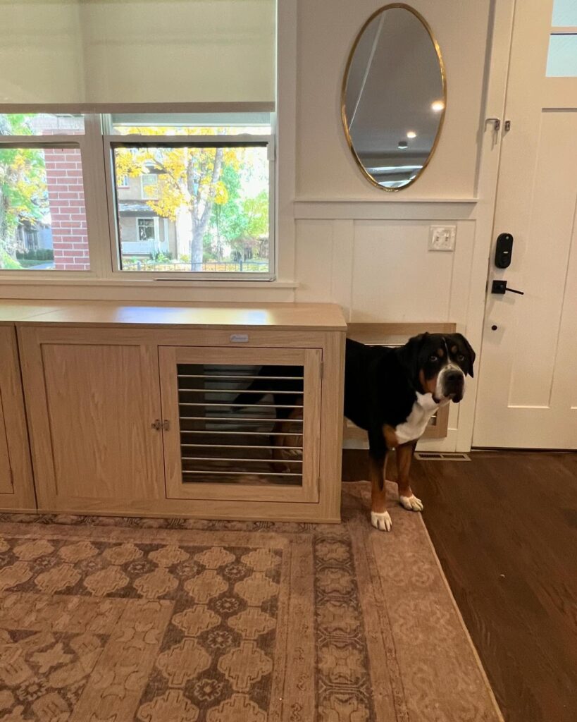 entryway oak console unit under window with louvered door built-in dog crate compartment