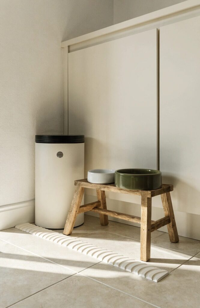 dog feeding station corner in kitchen with elevated bowls and food storage