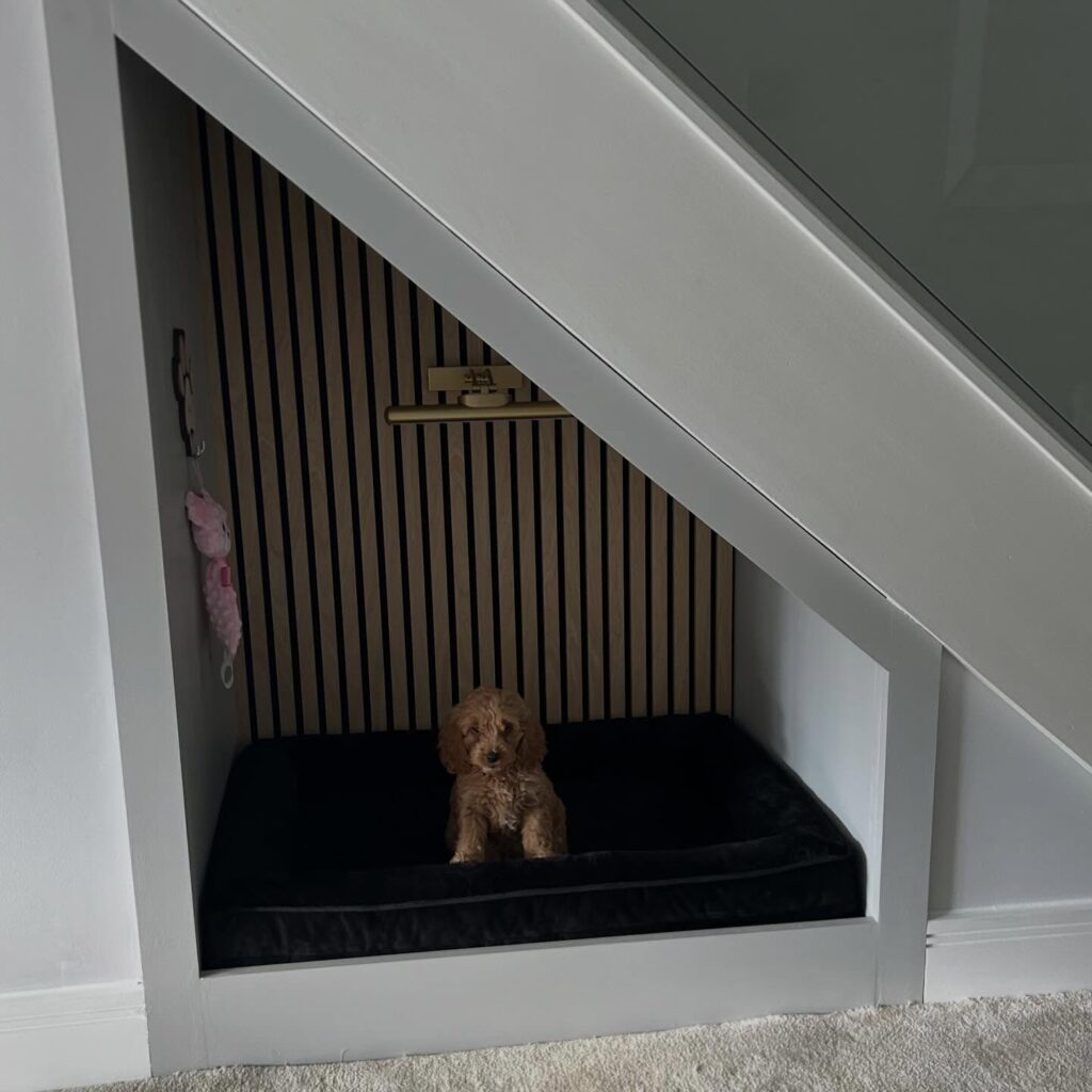 modern under stair dog nook featuring oak slat panels and dark velvet mattress