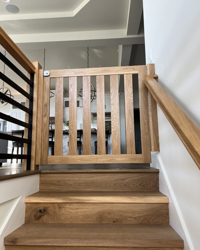 natural oak floating dog gate mounted between wall and banister