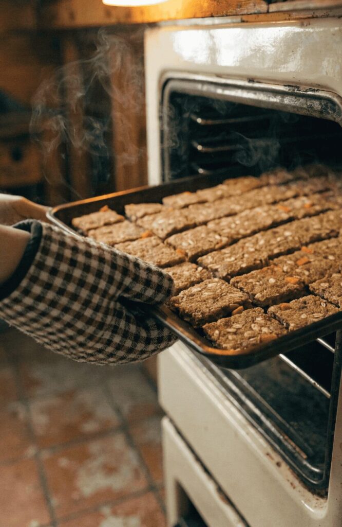 pulling baked beef carrot oat dog kibble from vintage farmhouse oven