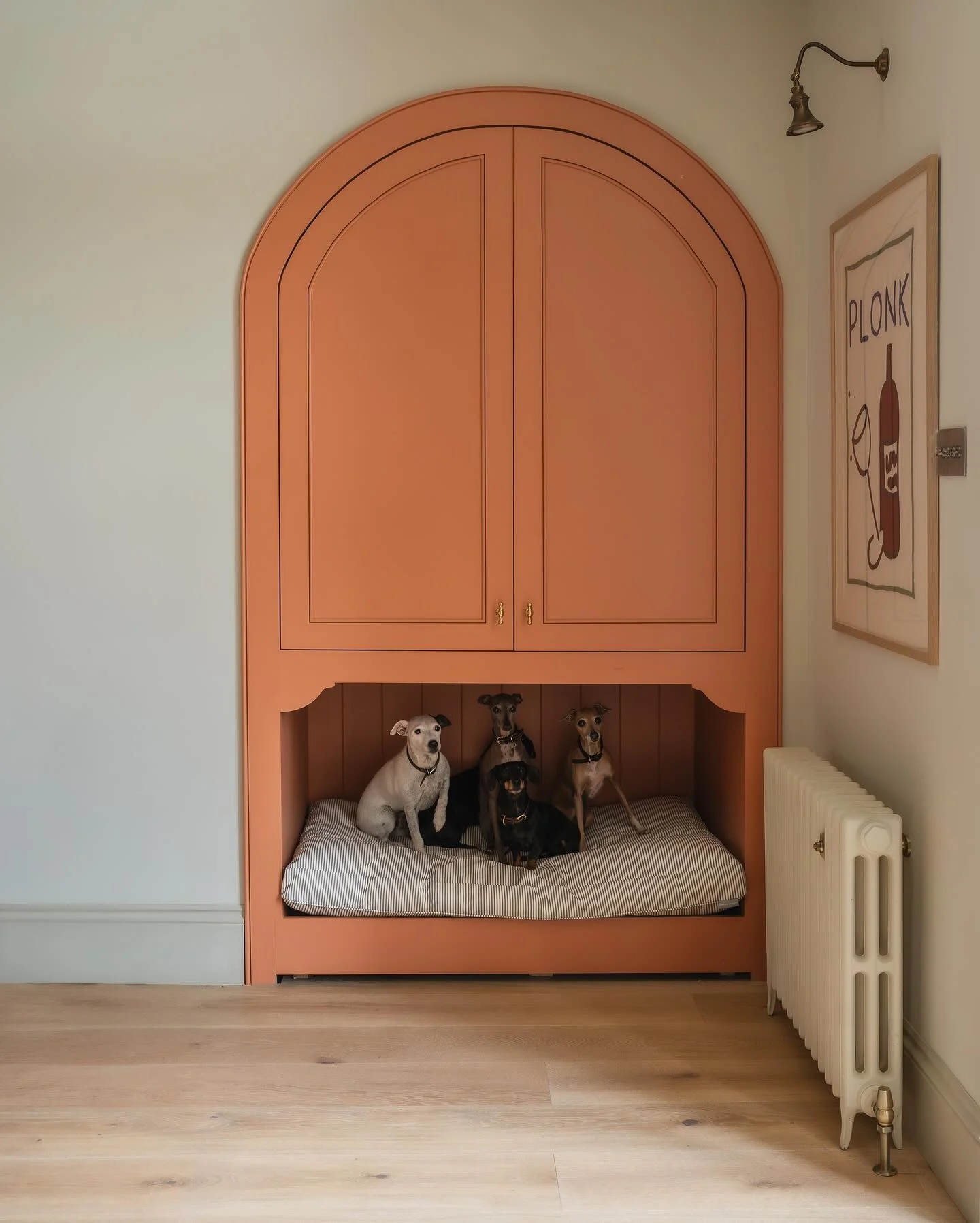 statement terracotta arched built-in cabinet with integrated dog sleeping bay for multiple dogs