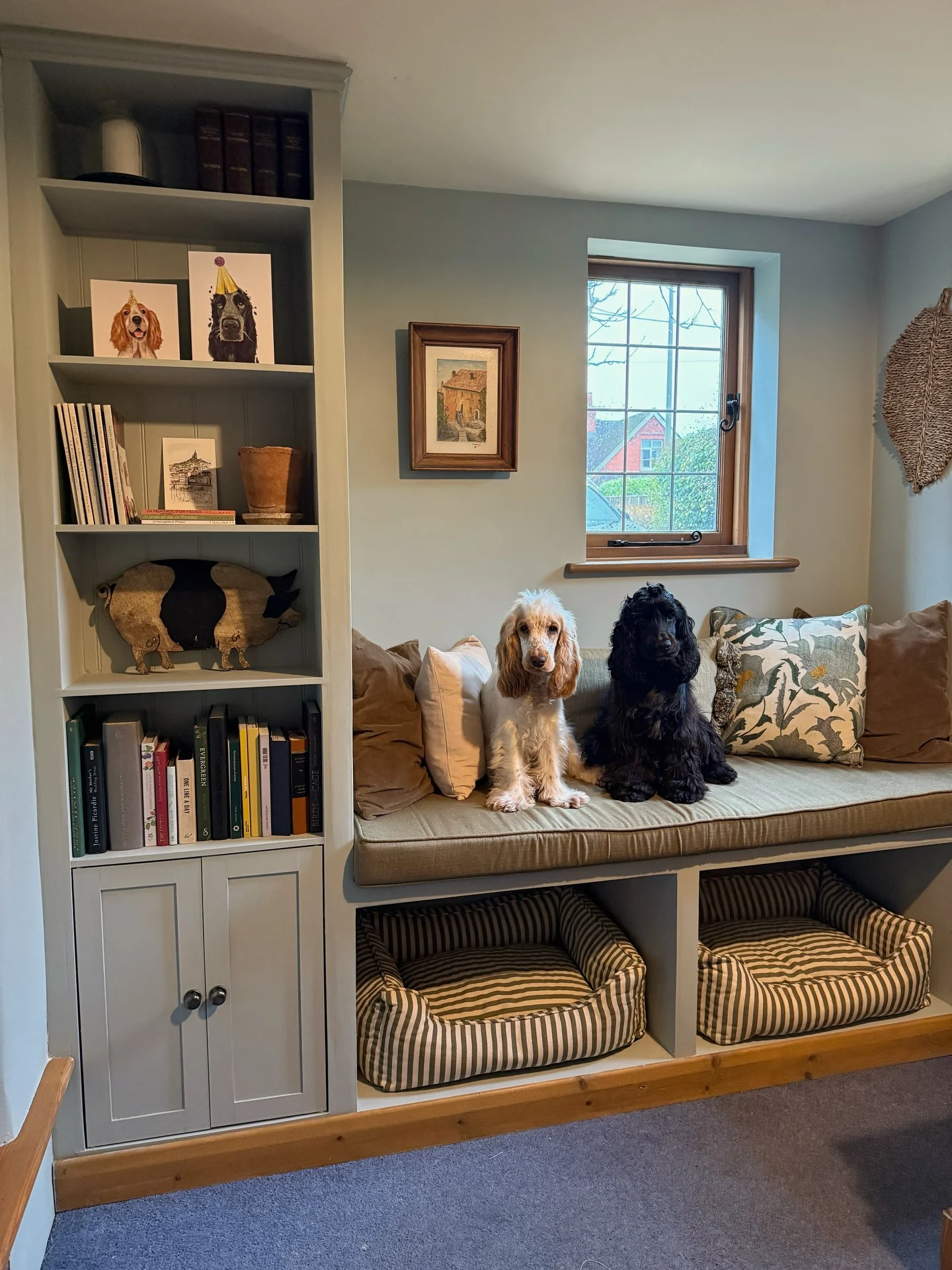 window bench seat with open under seat dog bed cubbies beside built-in bookcase