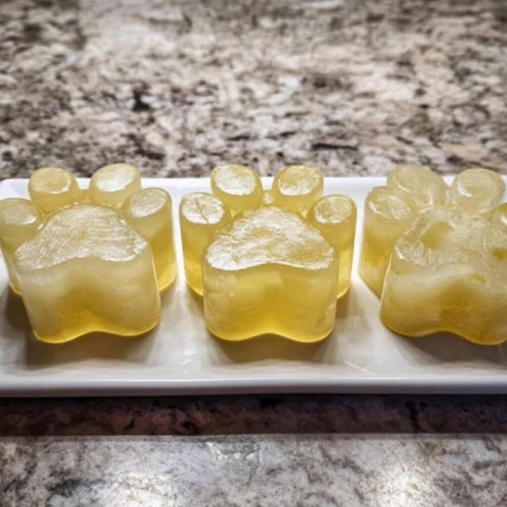 Pale yellow apple banana pawsicle in a paw shaped mold for dogs