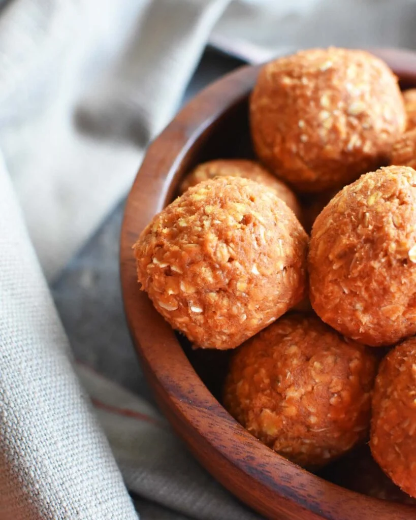 Pumpkin peanut butter oat balls for dogs served in a wooden bowl