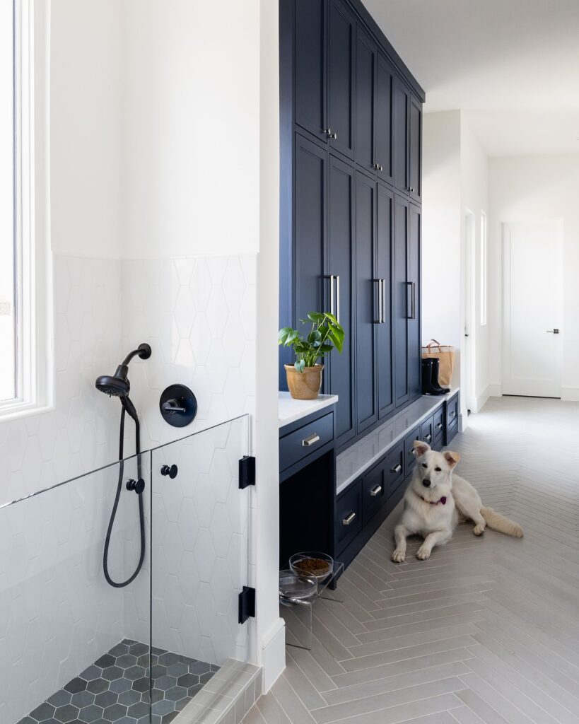 Dog eating beside built in navy cabinetry feeding station