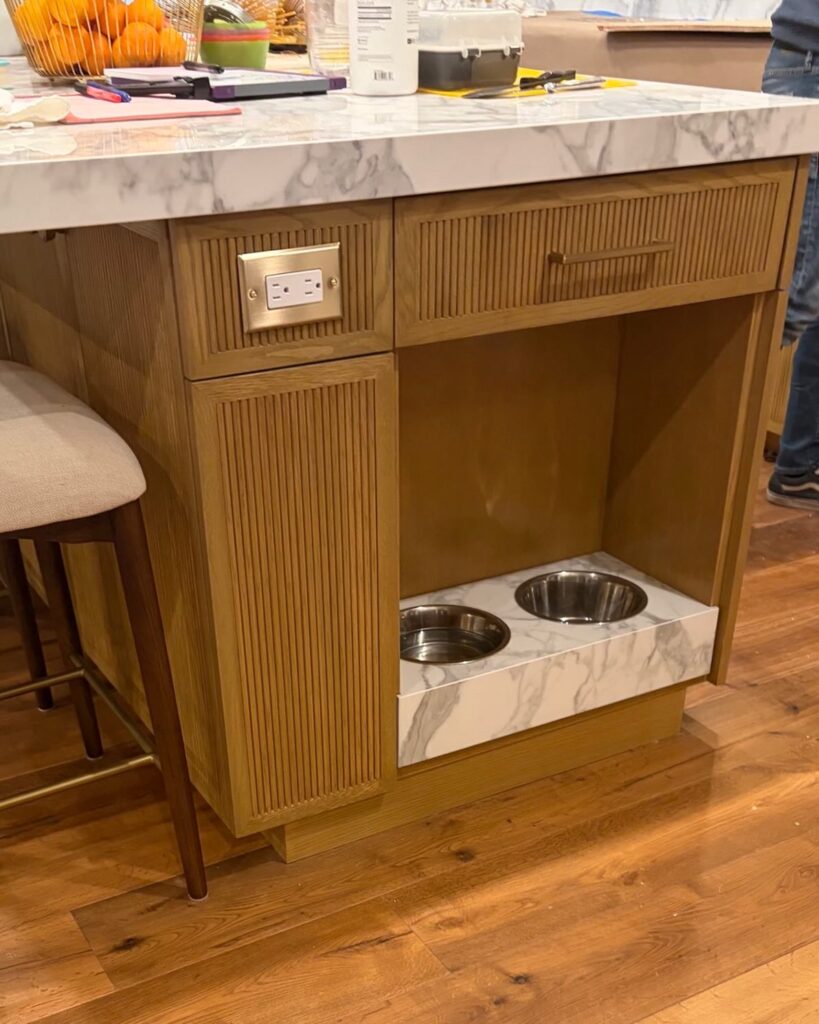 Fluted wood island niche with marble dog bowl riser