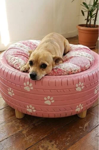 Upcycled tire raised dog bed idea painted pink with paw prints