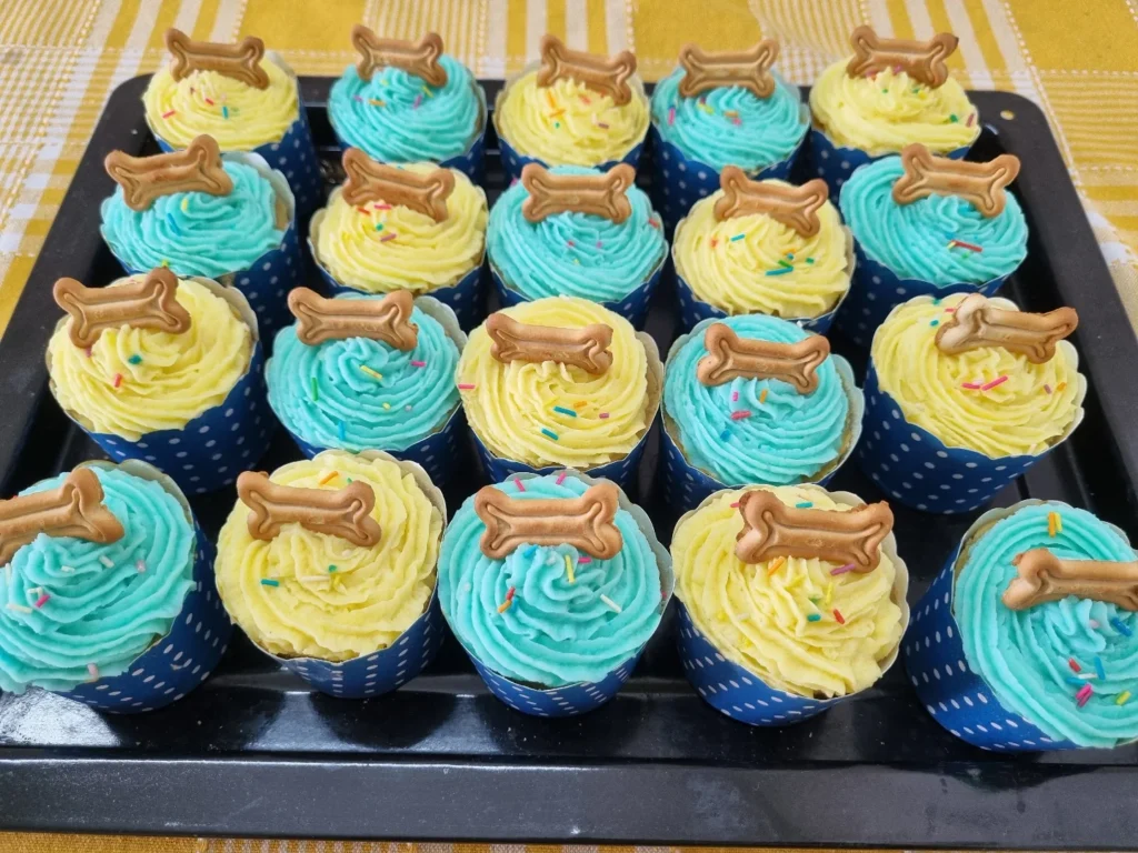 Bone-topped dog birthday cupcakes in blue and yellow party colors