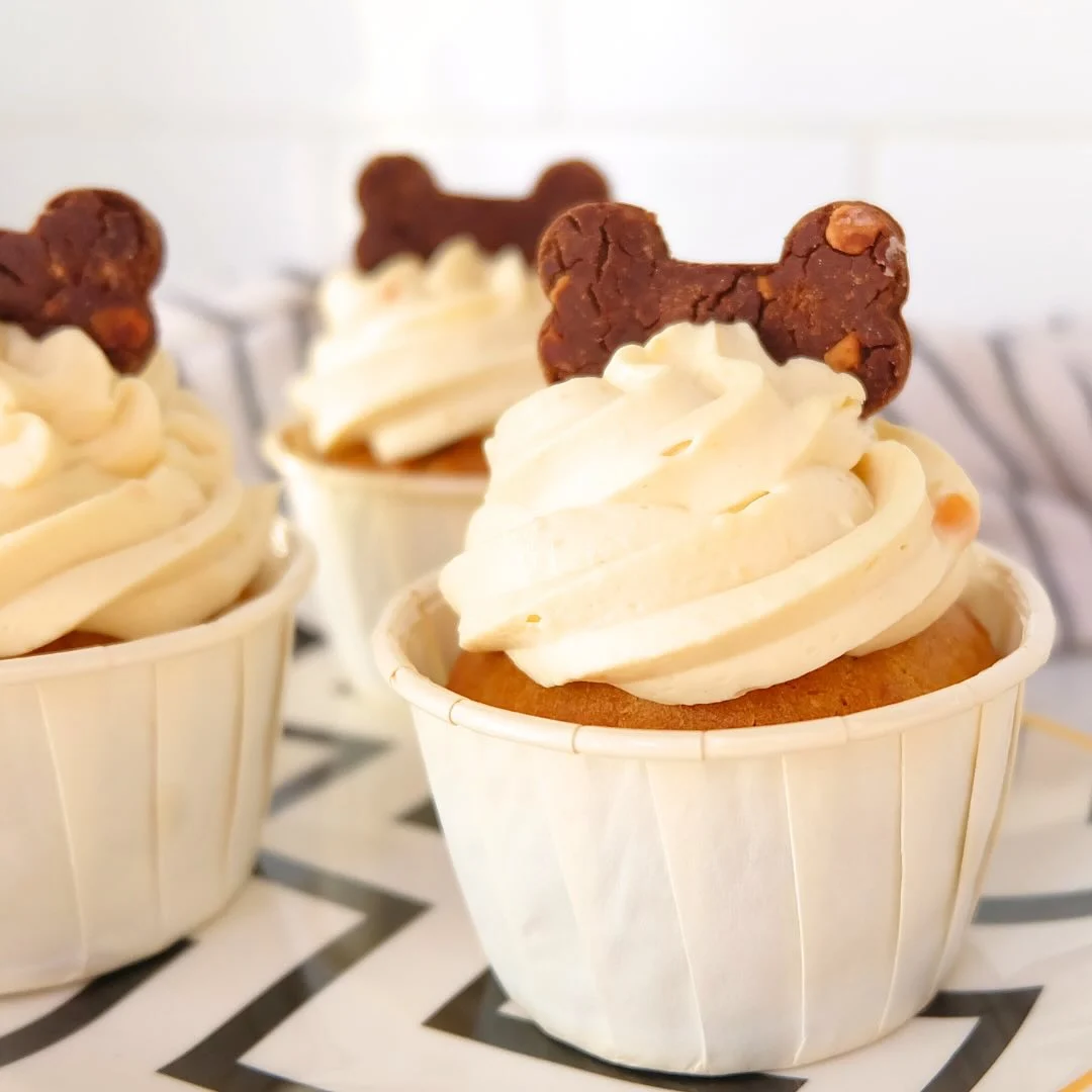 Classic peanut butter pupcake with cream frosting and biscuit topper