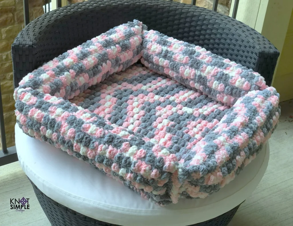 Pink and gray chenille bolster style crochet dog bed