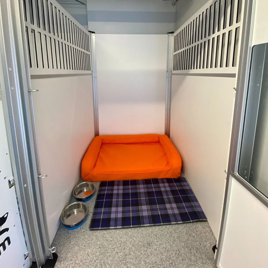 Branded numbered private suite with orange bed and bowls