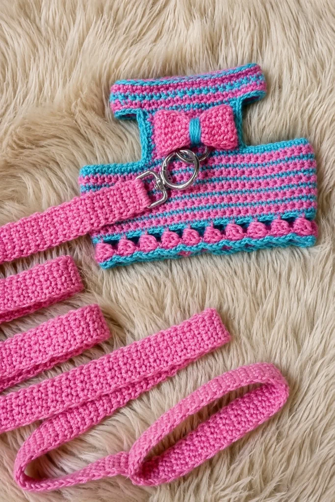 Pink and teal striped crochet dog harness with bow and bobble stitch trim