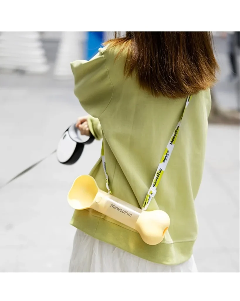 Wearable bone-shaped dog water bottle worn crossbody style