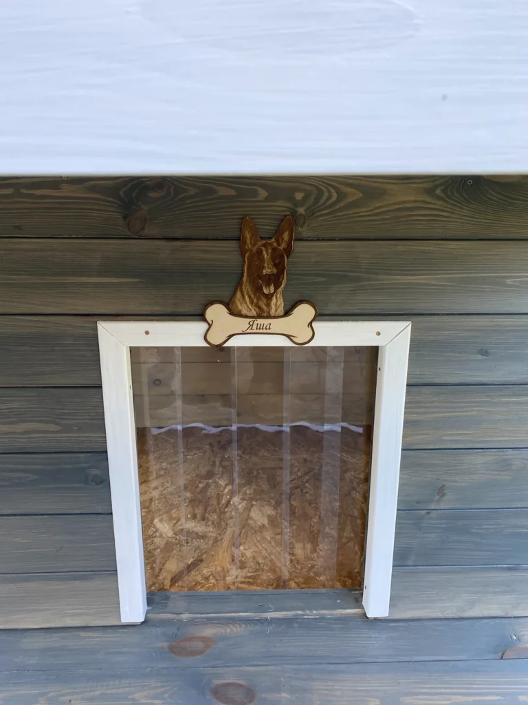 Close up of insulated dog house door with engraved nameplate