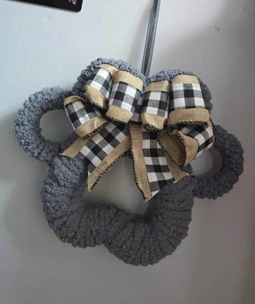Cozy boucle yarn dog paw wreath diy with buffalo check bow