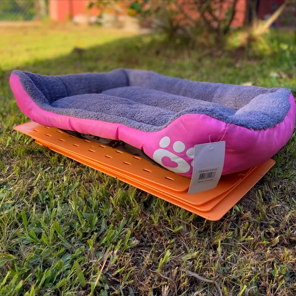 Pink and grey fleece bolster bed on folding outdoor mat base