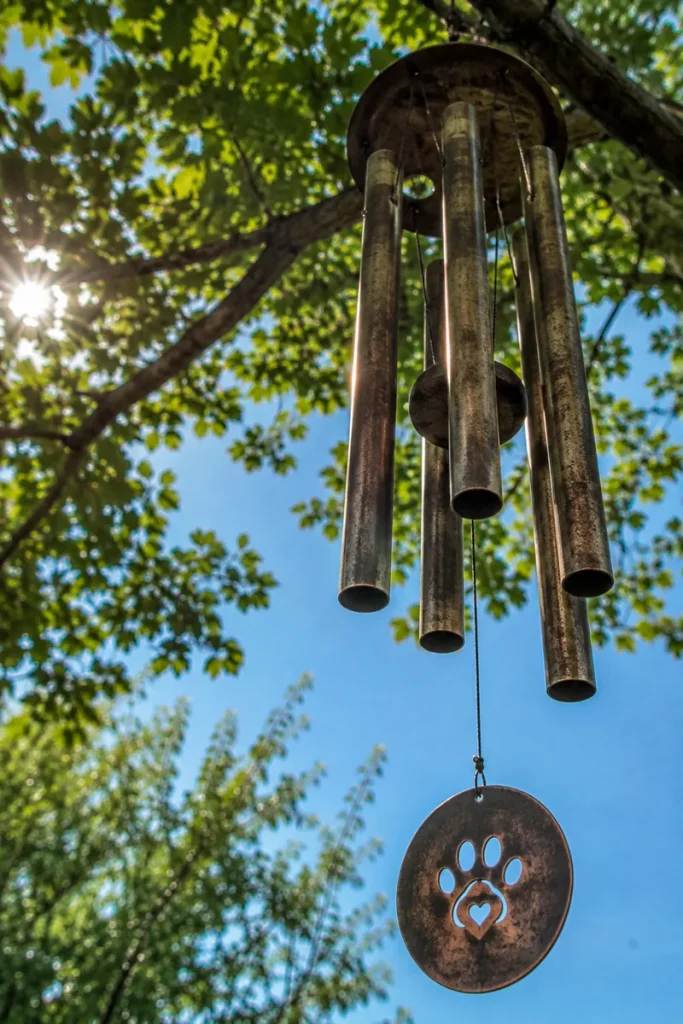 Bronze wind chime swaying gently in a memorial garden